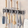 Wall-mounted metal holder for mop and broom with detachable hooks and storage
