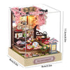 DIY miniature Japanese sakura tea house wooden kit featuring pink flowers and an LED light.