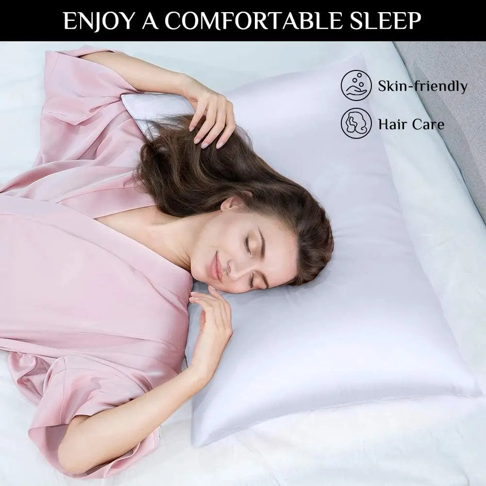 Una mujer durmiendo cómodamente en una almohada blanca con funda de satén de seda rosa y una blusa a juego.