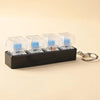 A black LED mechanical keychain fidget toy with multiple clear and blue keycaps is shown on a light background.