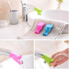 Flexible silicone faucet extenders in pink, blue, and green colors used for handwashing.