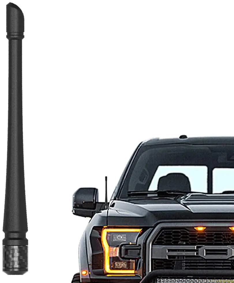 A black universal car radio antenna is shown next to a black pickup truck grille.