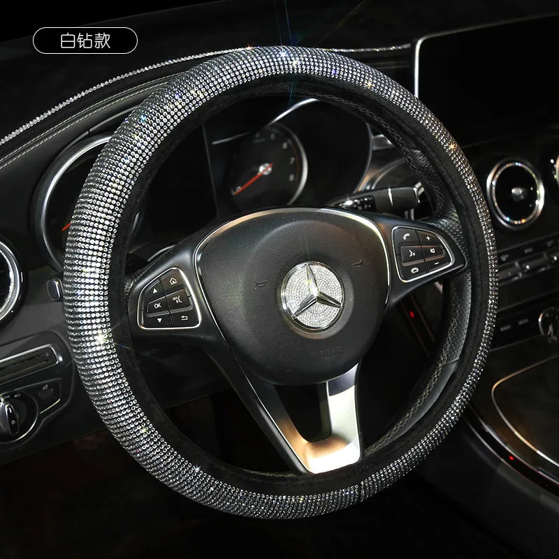 A close-up view of a black steering wheel covered in sparkling crystal rhinestones.