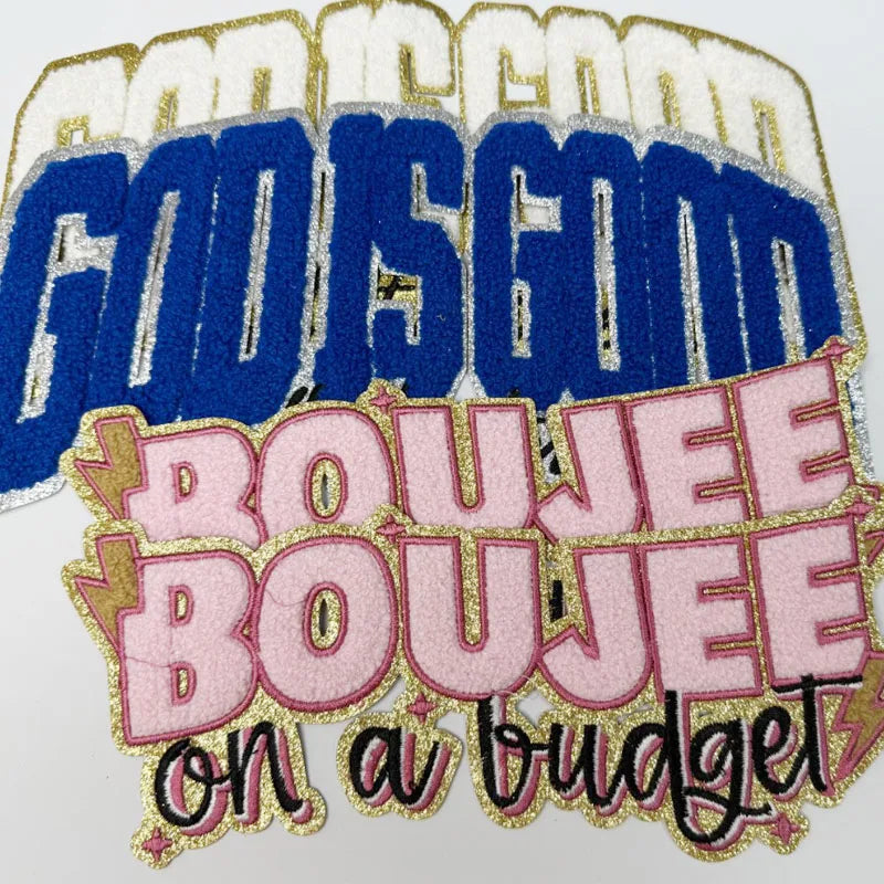 Embroidered patch featuring the text God Is Good and Boujee on a budget in gold and pink thread.