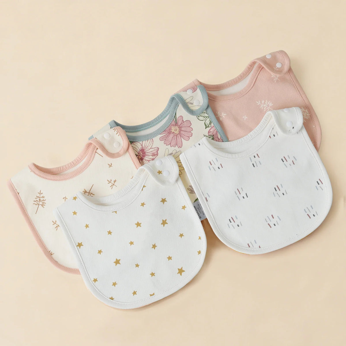 A collection of pink, blue, and white cotton baby bibs with floral and star patterns displayed on a light background.