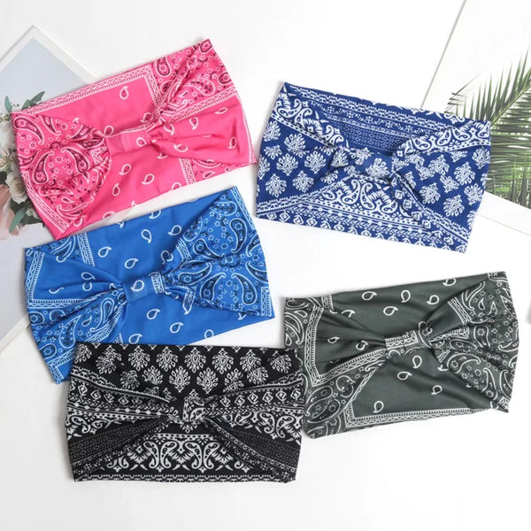 A collection of five colorful bohemian elastic headbands in pink, blue, and black patterns for hair and yoga.
