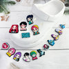 Un charm de chaussure blanc avec divers charms de personnages chibi aux cheveux foncés et tenues colorées