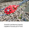 A red heavy duty snatch block is shown attached to a thick rope in an outdoor setting.
