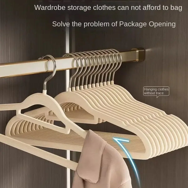 A set of five stainless steel non-slip hangers are shown hanging on a wooden rod in a closet.