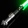 A silver lightsaber with a green blade and a textured grip is shown against a black background.