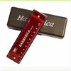 A red harmonica with numbered holes is shown inside its protective black case.