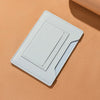 A light blue leather passport holder with card slots lying on a beige surface.