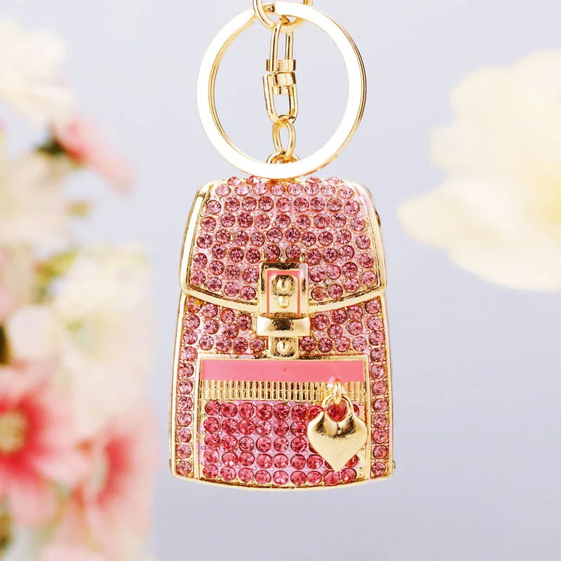 Gold and pink crystal rhinestone handbag keychain with a circular loop.