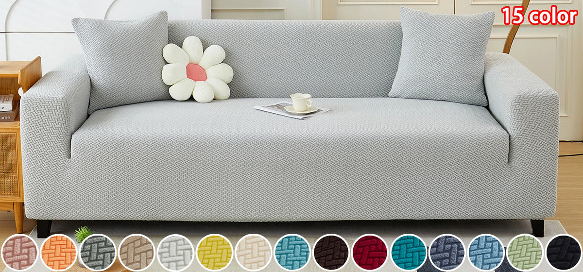 A light gray elegant jacquard sofa slipcover with decorative pillows and a floral accent.