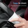 A hand is wiping a carbon fiber texture steering wheel cover on a car interior surface.