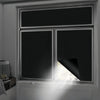 A close-up view of a modern window with black privacy film installed, showing sunlight streaming through the glass.