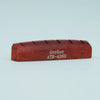 A wooden acoustic guitar bridge saddle with the name Guyker and part number ATR-4369 engraved on it.