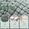 A close-up of soft gray multi-layered cotton muslin baby burp cloths with three feature icons.