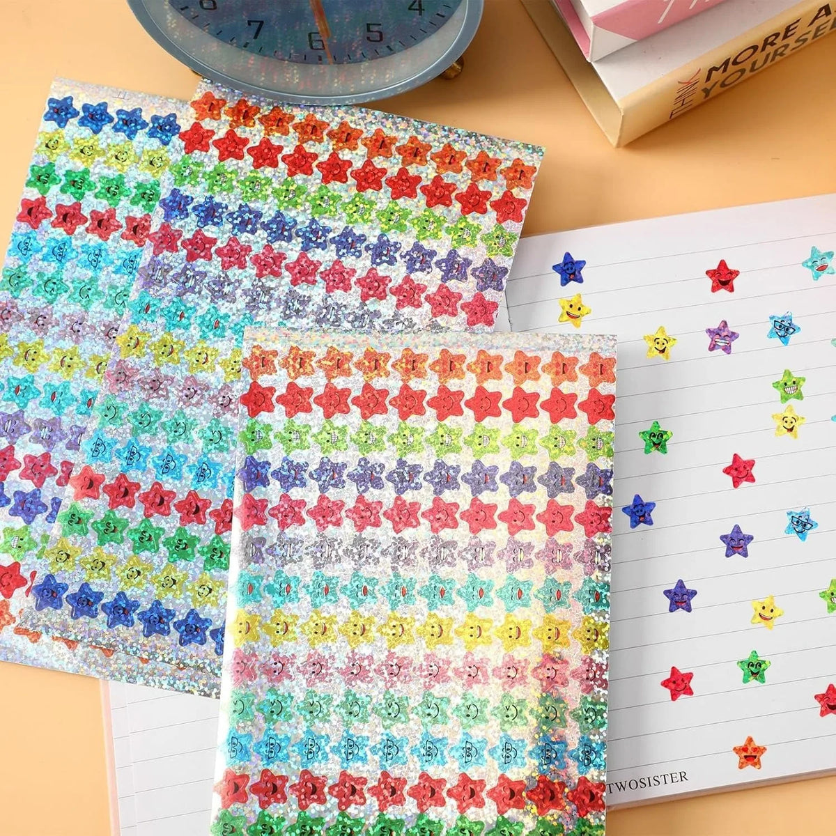 A sheet of colorful glitter star stickers and a notebook page with various star designs.