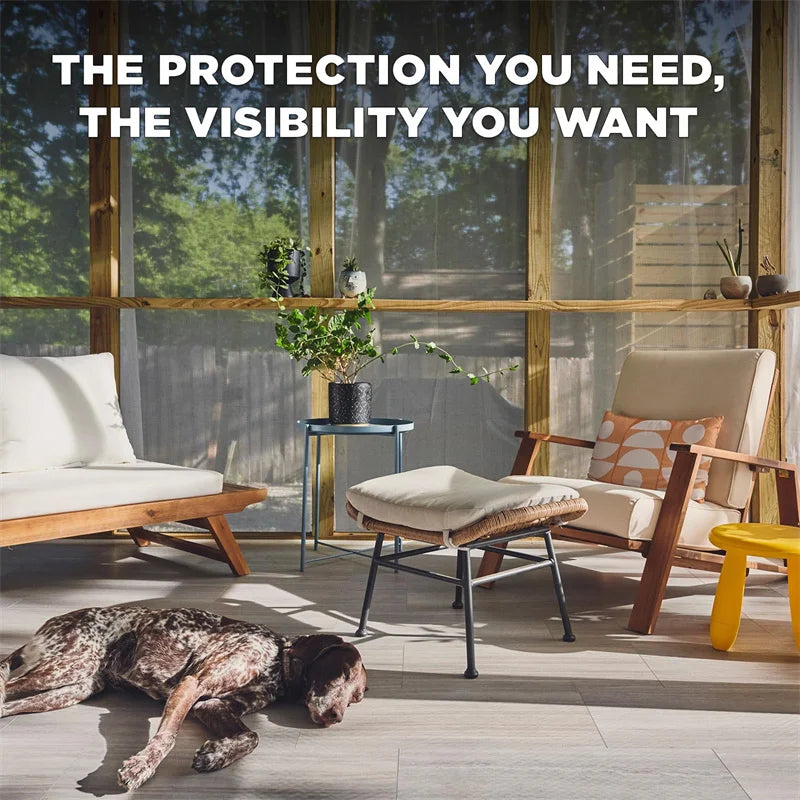 A living room scene showing a dog resting on the floor near wooden furniture and large glass windows with a mesh screen visib