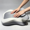 A hand is pressing a multi-positional memory foam body pillow with a removable cover, showing its soft, contoured shape.