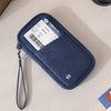 A dark blue RFID-blocking passport holder and travel document organizer with a lanyard, placed on a light surface.