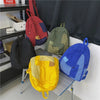 A collection of colorful canvas patchwork backpacks displayed on a shelf.