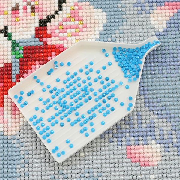 Un outil de peinture diamant blanc avec des perles bleues sur un fond de perlage coloré.