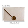 A pale beige linen texture envelope with a gold sealing wax sticker on the front.