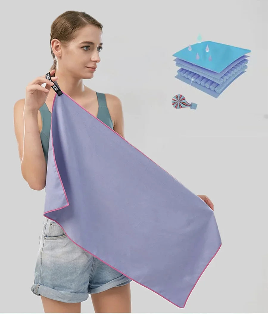 A purple microfiber sports towel is shown being held by a woman against a light gray background.
