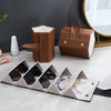A brown leather foldable multi-slot organizer case holding various pairs of sunglasses.