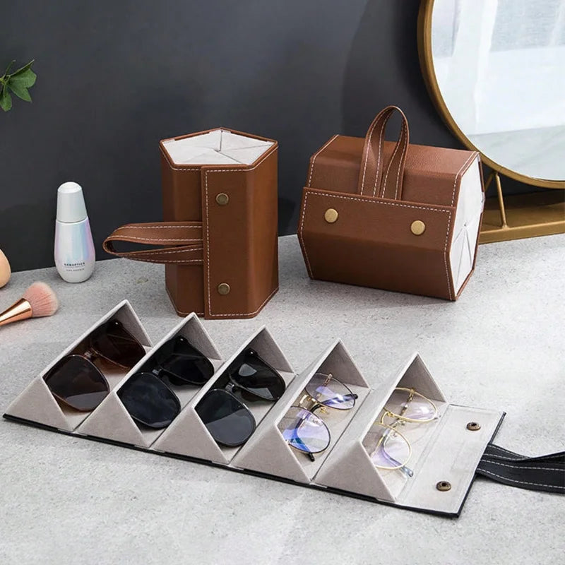 A brown leather foldable multi-slot organizer case holding various pairs of sunglasses.