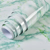 Roll of waterproof self-adhesive marble wallpaper featuring green veining on a white background.