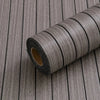 Roll of extra thick 3D wood grain self-adhesive wallpaper on a wooden surface