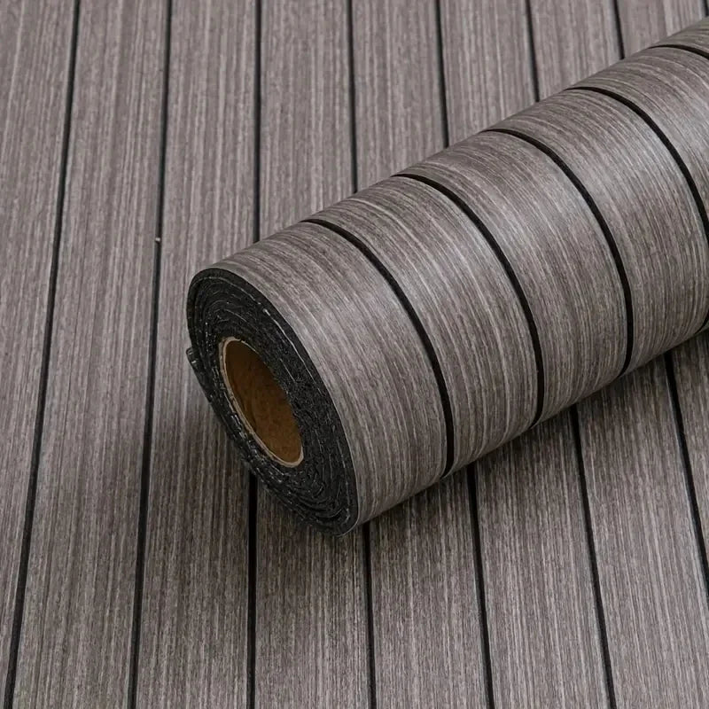 Roll of extra thick 3D wood grain self-adhesive wallpaper on a wooden surface