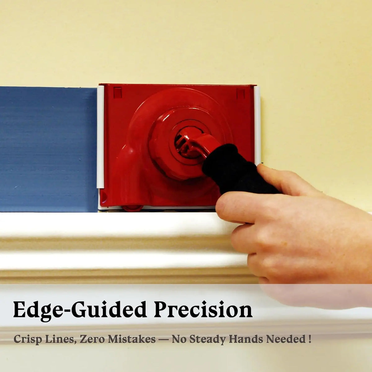 A hand is using an edge-guided precision paint tool to apply paint along a wall edge.