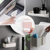 A hand is shown placing removable adhesive picture hanging strips into a white storage container.