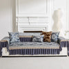 A navy blue and gold patterned sofa cover with quilted protection displayed against a white fireplace mantel.