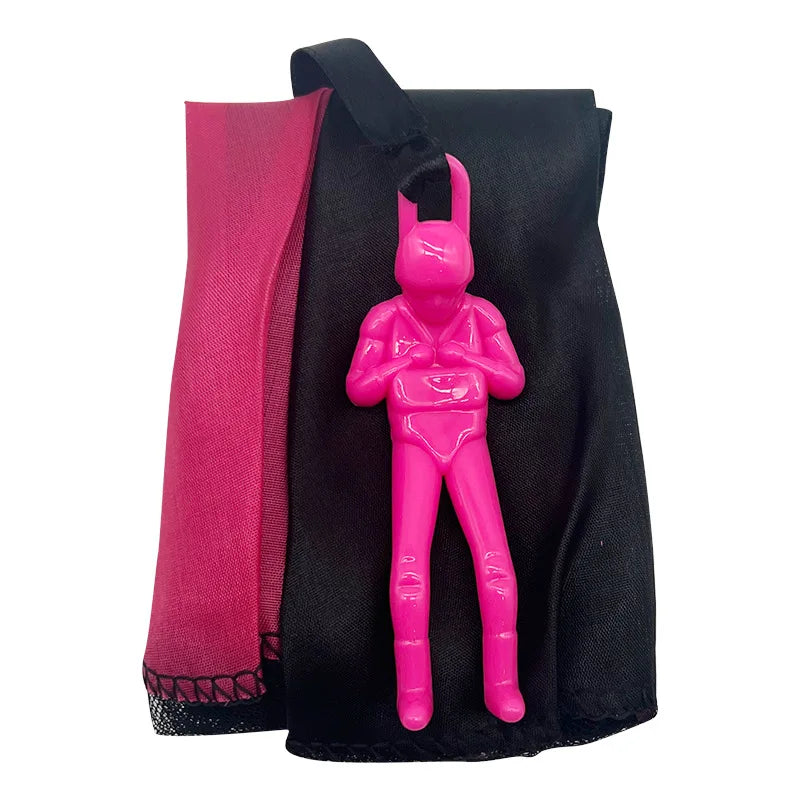A pink hand-throw parachute toy with a mini soldier figure is shown against a black fabric background.