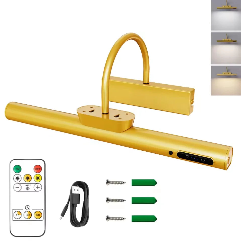 A golden cordless rechargeable picture light fixture with a long bar and remote control and accessories.