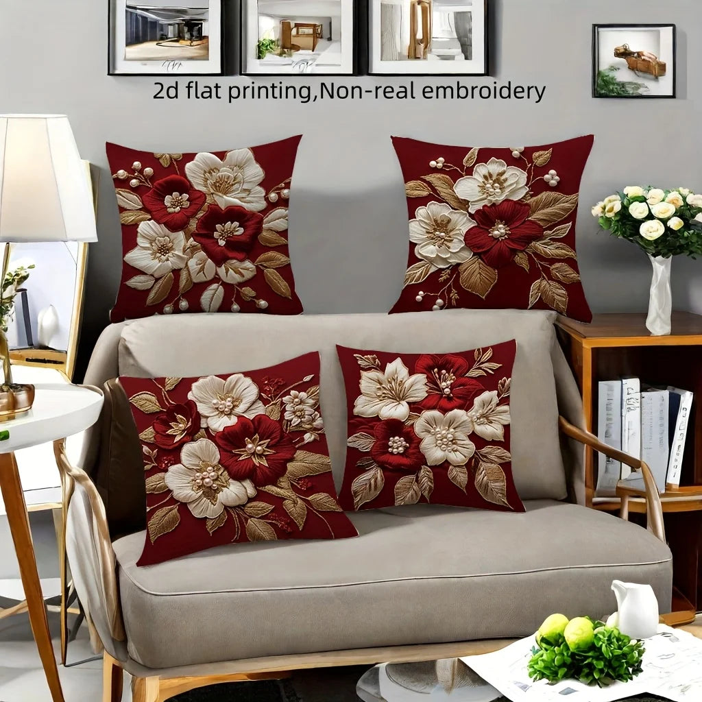 A set of red floral decorative pillowcases featuring white and deep red flowers embroidered on a neutral sofa.