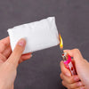 A hand holds a white moldable sealing clay block near a flame, demonstrating its use for sealing gaps.