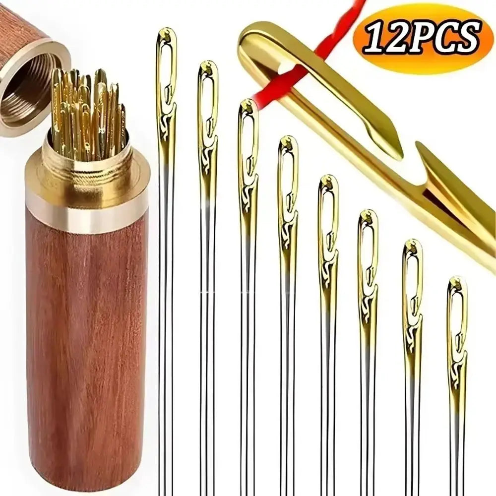 A set of 12 gold-tipped sewing needles with side holes housed in a wooden casing and featuring a gold-colored tool.