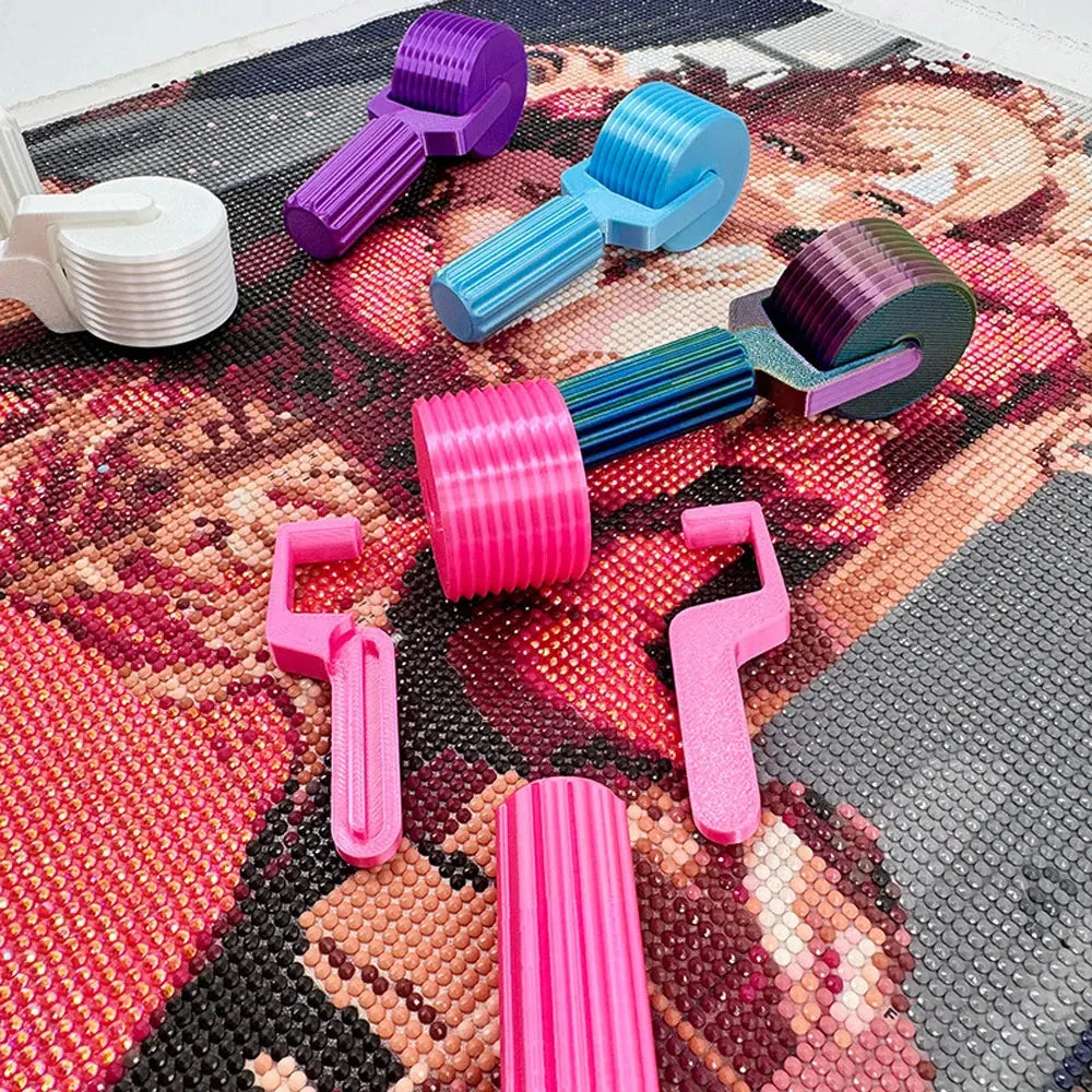 A collection of colorful, detachable diamond painting roller tools in various shades of purple, blue, pink, and green scatter