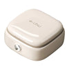 A compact, light beige magnetic sewing kit with a lid and a silver button.