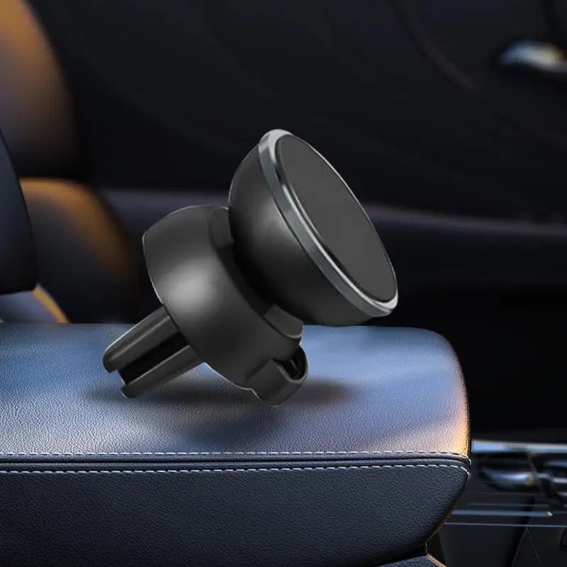 Support magnétique universel noir pour téléphone, posé sur un siège de voiture en cuir foncé.
