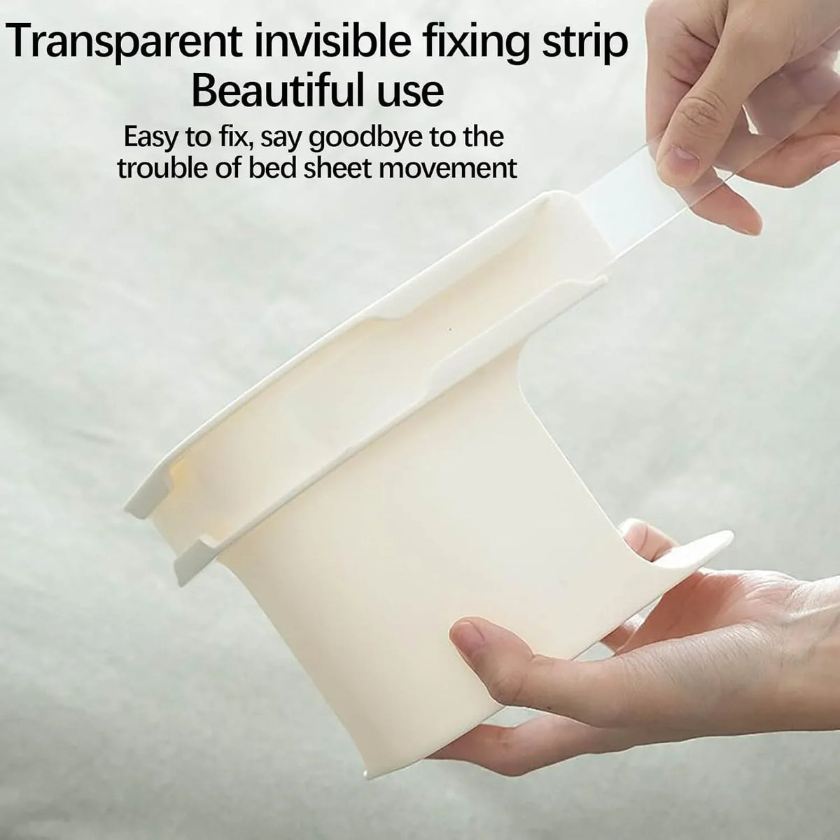 A hand is holding a transparent invisible fixing strip used to secure a bed sheet corner.
