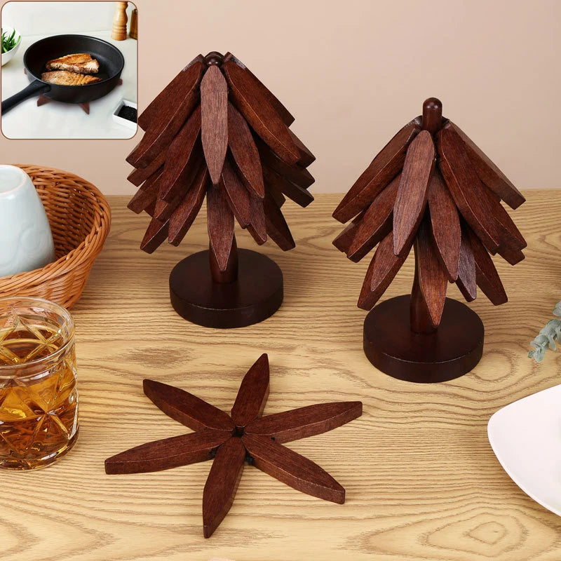 A set of dark brown wooden tree design coasters and folding placemats displayed on a light wood surface.