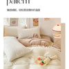 A close-up of a beige milk fleece velvet bedding set featuring a duvet cover and pillows on a bed.
