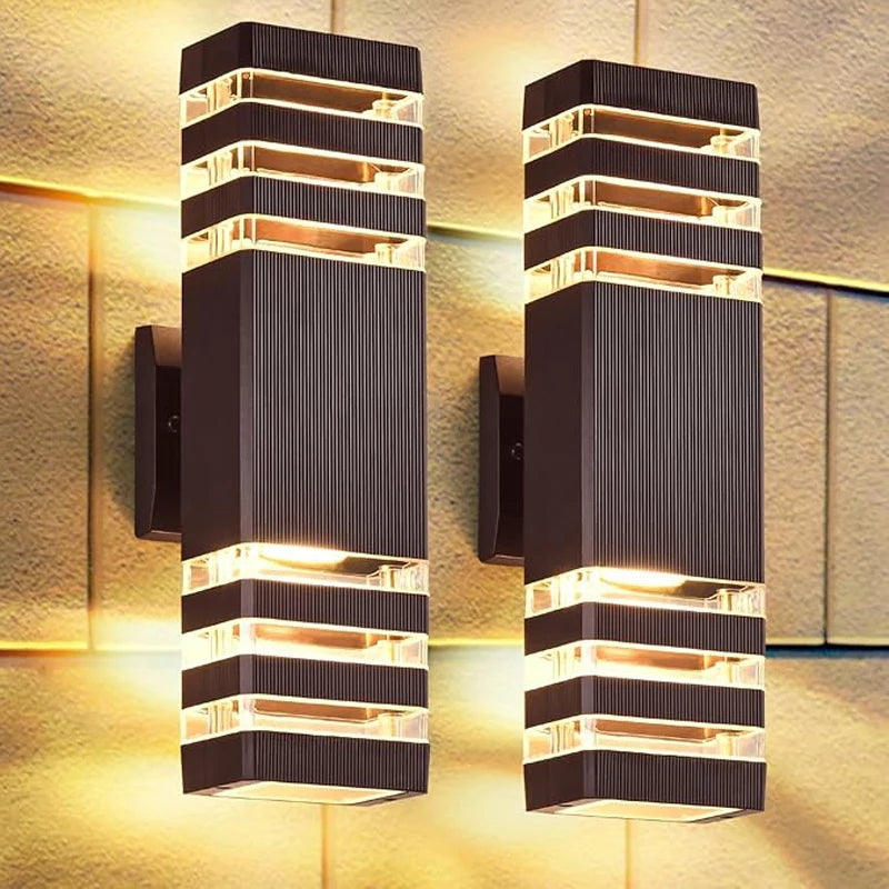 A pair of modern black LED wall sconces with vertical light strips mounted on a textured wall.